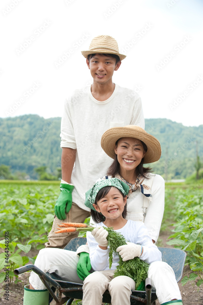 畑の中で一輪車に乗る三人家族 畑の中で一輪車に乗る三人家族