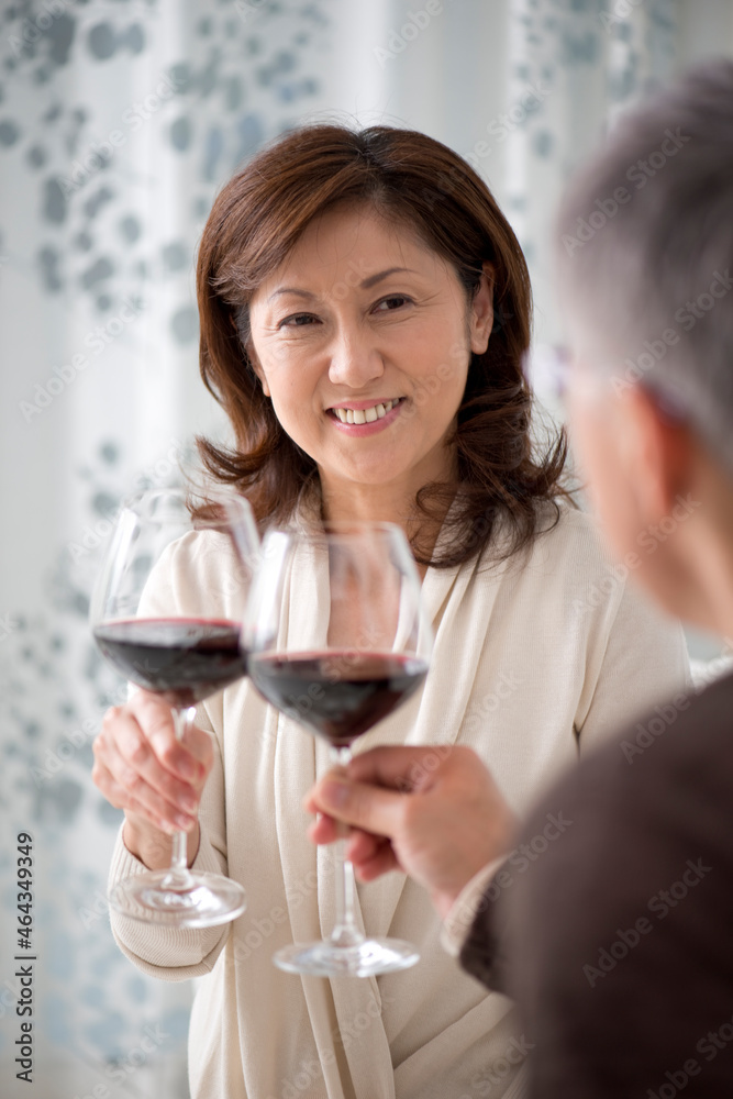 赤ワインで乾杯する中高年夫婦 赤ワインで乾杯する中高年夫婦