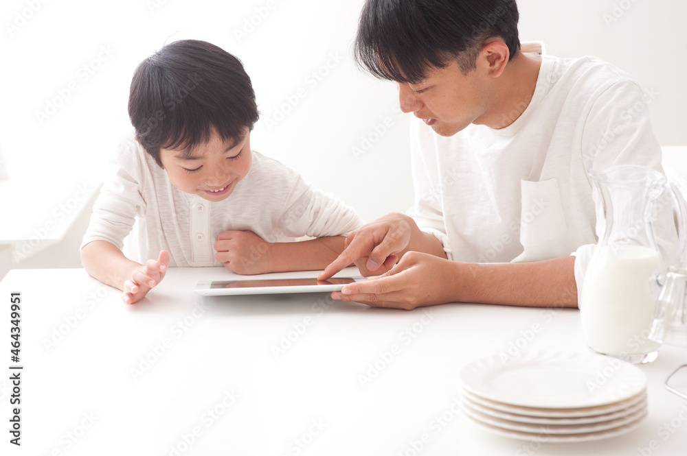 食卓でタブレットPCを見る父と男の子 食卓でタブレットPCを見る父と男の子