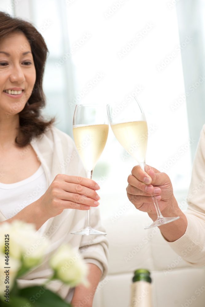シャンパンで乾杯する中高年夫婦