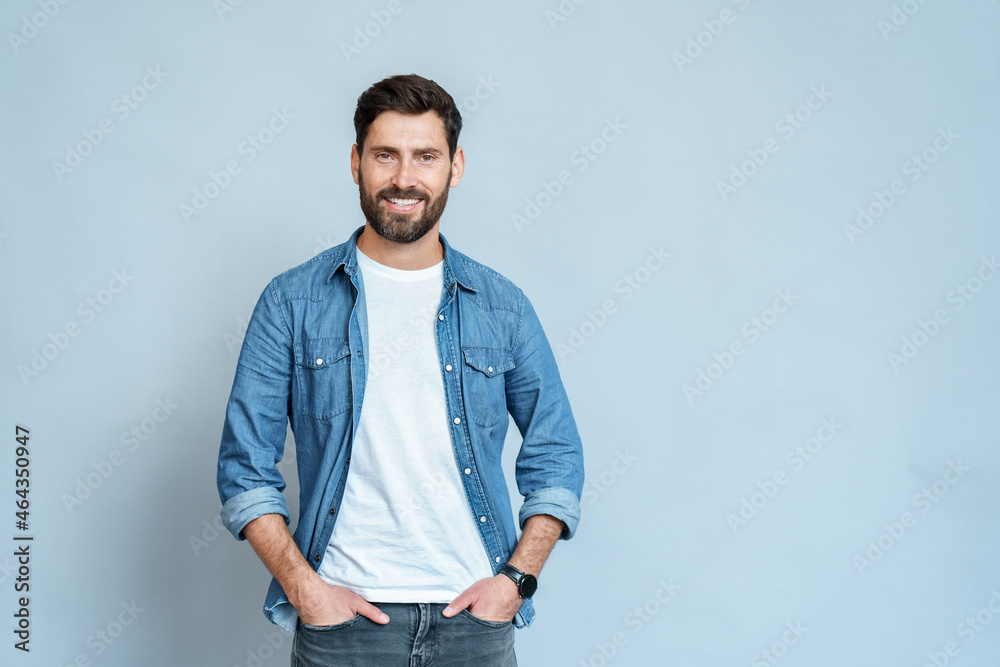 Fototapeta premium Handsome young man isolated on blue background looking at camera and smiling