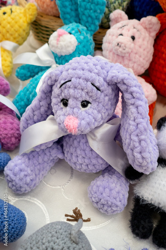Knitted colored bunnie handmade toy on display in gifts and crafts market. To illustrate hobbies, creativity, leisure