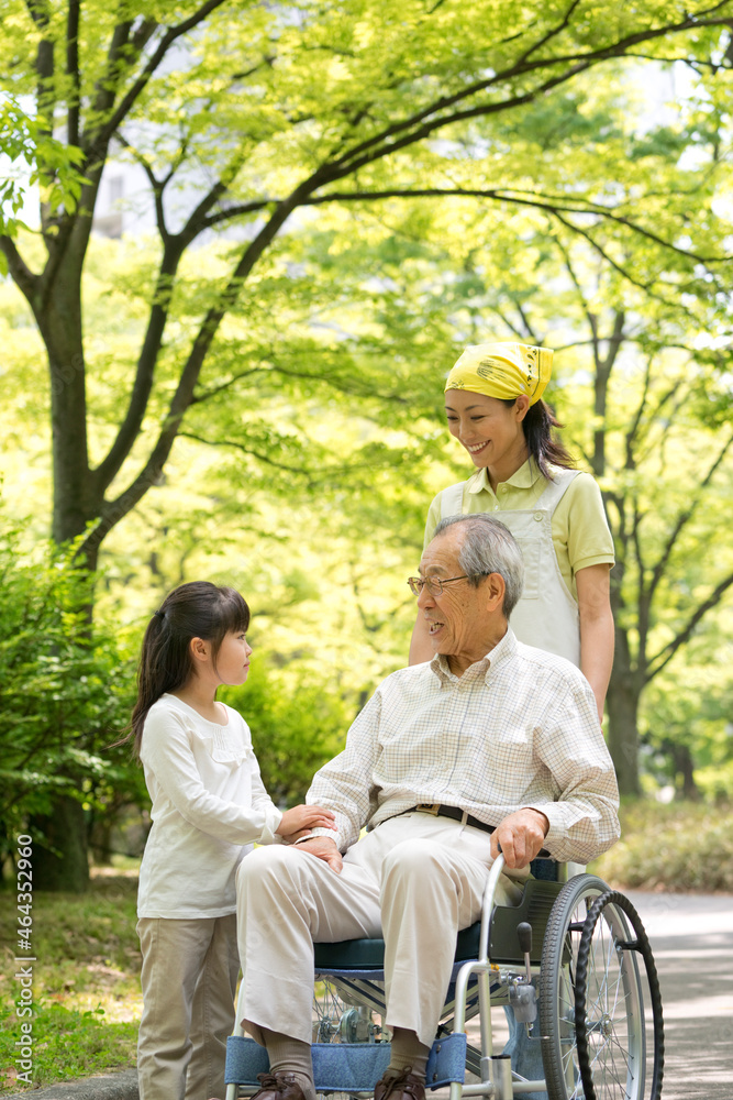 車椅子の老人と孫と介護ヘルパー 車椅子の老人と孫と介護ヘルパー