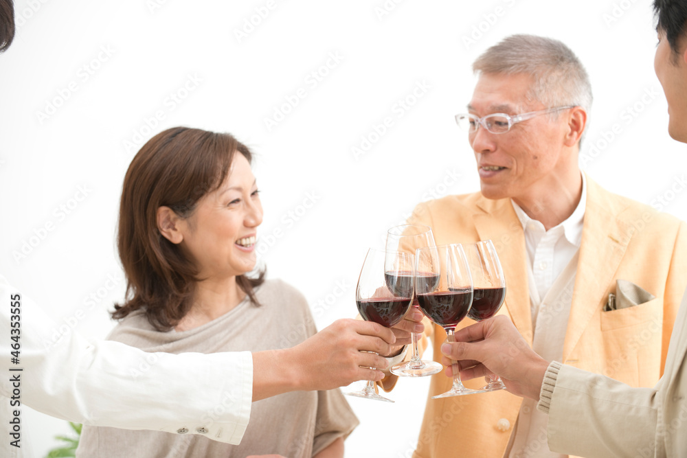 赤ワインで乾杯する中高年夫婦とホームパーティーのお客様 赤ワインで乾杯する中高年夫婦とホームパーティーのお客様