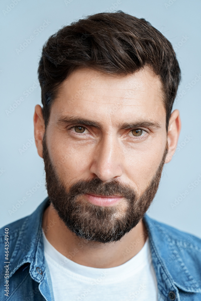 Obraz premium Closeup face portrait of bearded man isolated on blue studio background