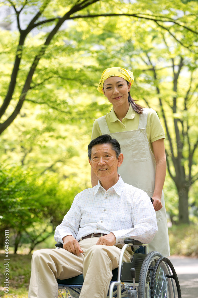 車椅子の老人と介護ヘルパー 車椅子の老人と介護ヘルパー