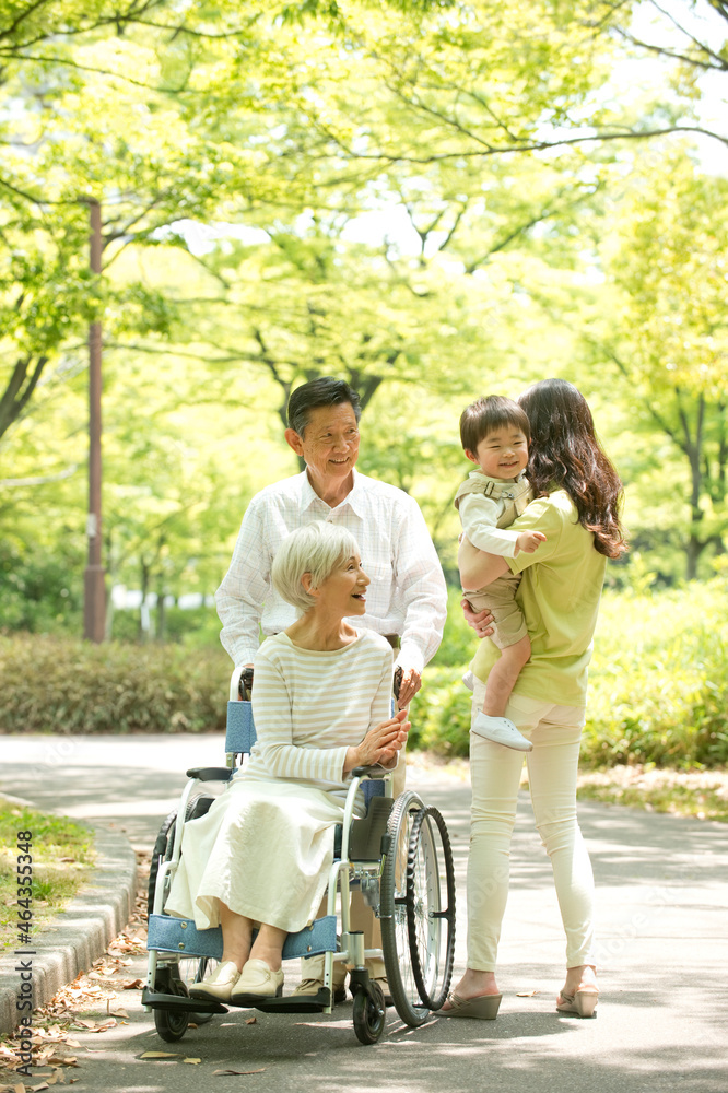 車椅子の老人夫婦と子供を抱く女性 車椅子の老人夫婦と子供を抱く女性