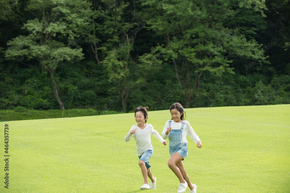 公園を走る子供男女