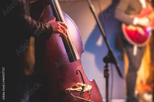 Foto Concert view of a contrabass violoncello player with vocalist and musical band d