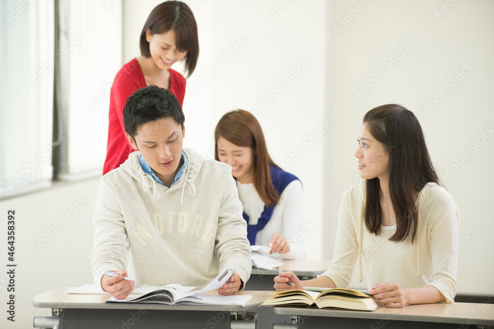 講義室で自習する大学生男女四人