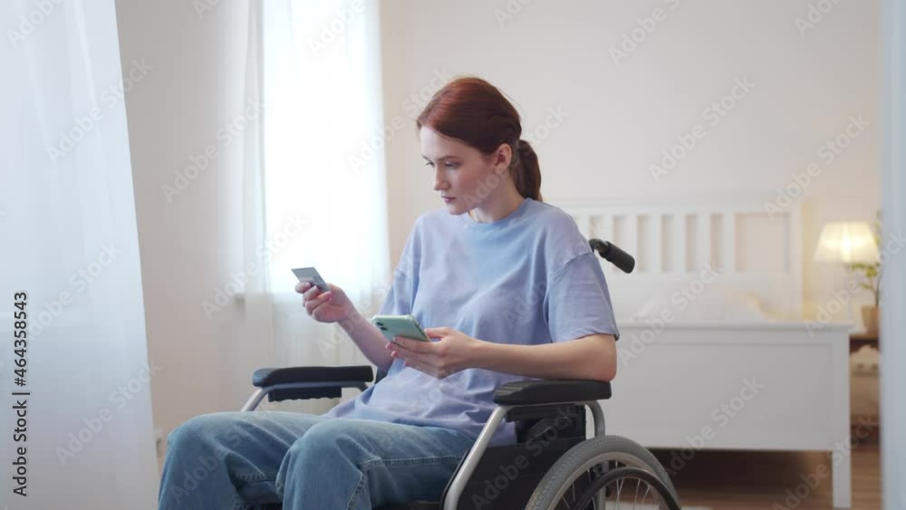 A disabled young girl dials a number from a bank card A disabled young girl dials a number from a bank card