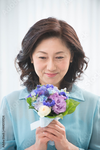 花のブーケを持つ中高年女性 photo