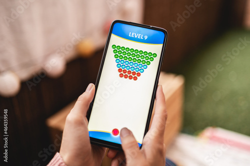 Girl gamer playing blockchain game online on mobile phone - Crypto currency technology trends photo