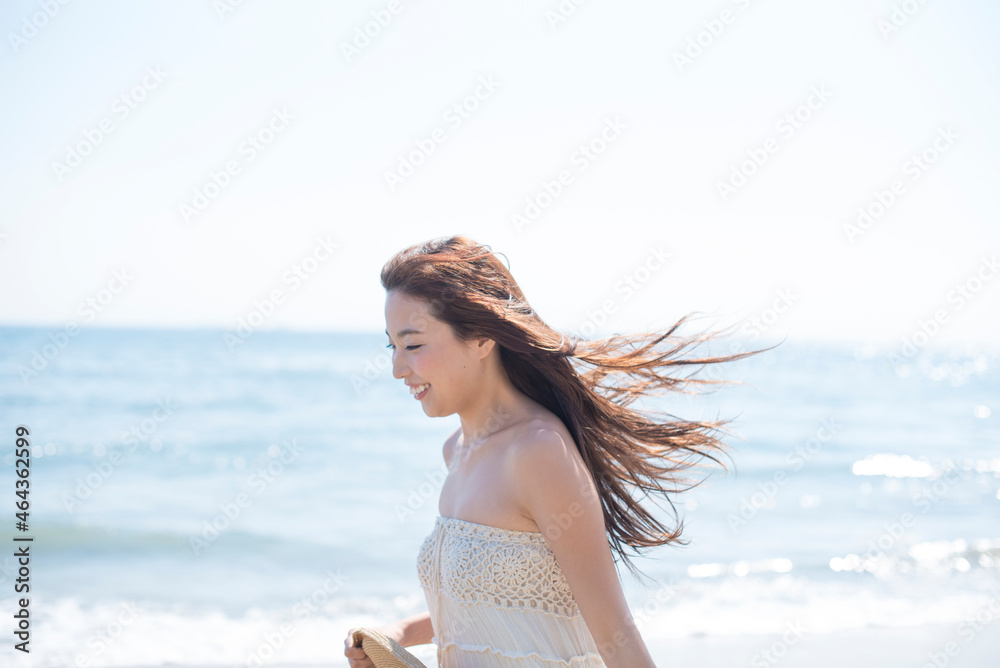 海の砂浜を素足で散歩する女性 海の砂浜を素足で散歩する女性