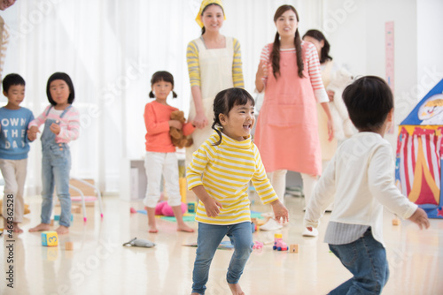 保育園で遊ぶ園児と保育士