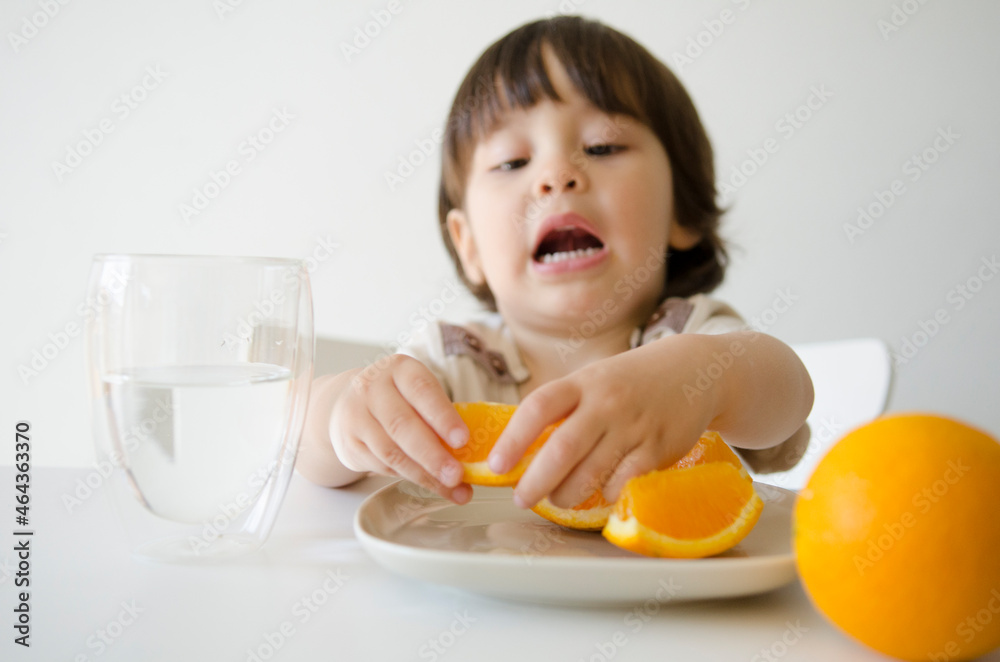 オレンジを食べようとしているハーフの男の子 オレンジを食べようとしているハーフの男の子