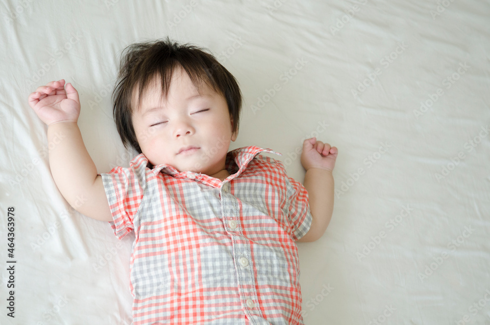 シーツの上でで眠る男の子