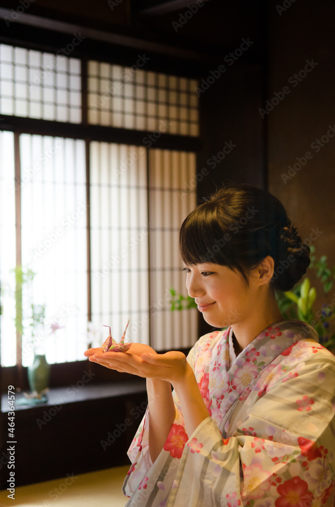 手のひらに折り鶴を乗せた着物姿の女性 手のひらに折り鶴を乗せた着物姿の女性
