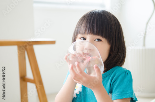 風船を膨らませている女の子
