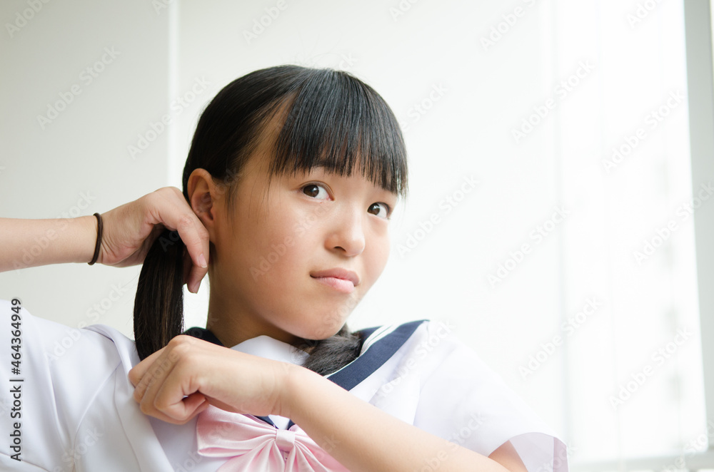 髪を結っている制服姿の女の子 髪を結っている制服姿の女の子