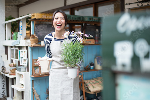 お花の鉢を持って笑っている女性 photo