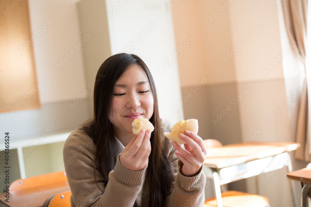 教室でパンを食べている女子高校生 教室でパンを食べている女子高校生