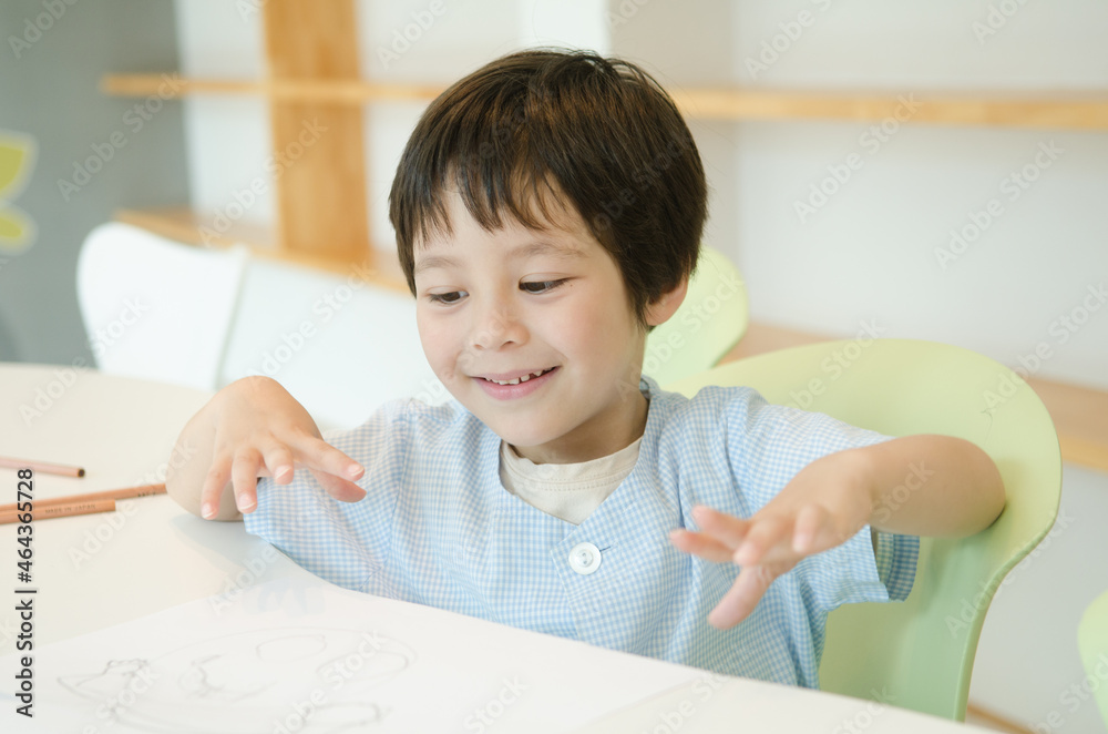 スモックを着て笑う子供