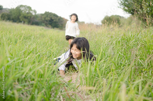 草むらで転ぶ女の子 photo