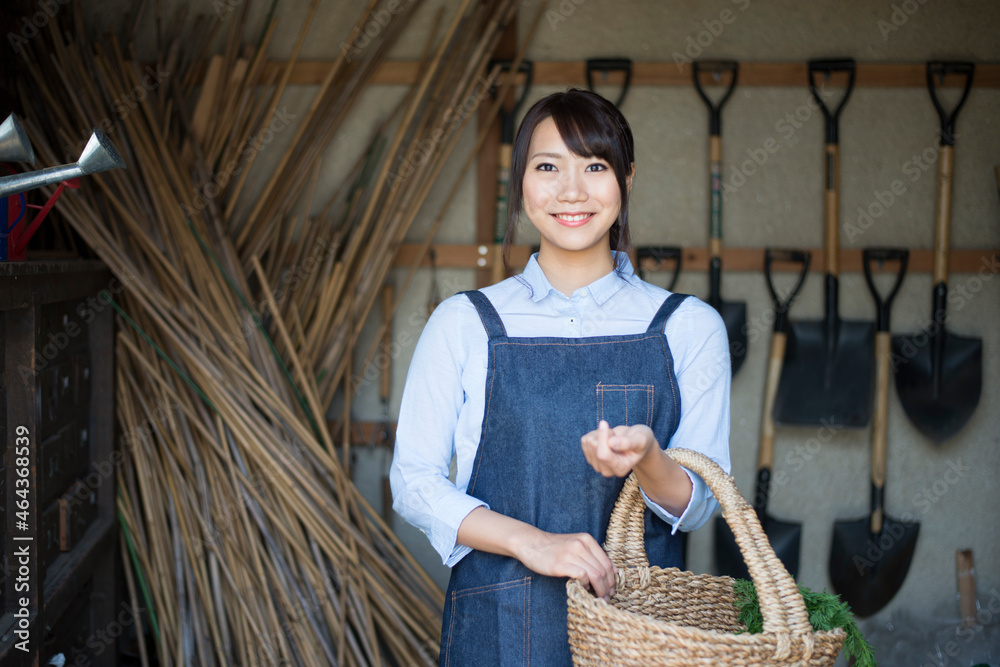 納屋でかごを持っている女性