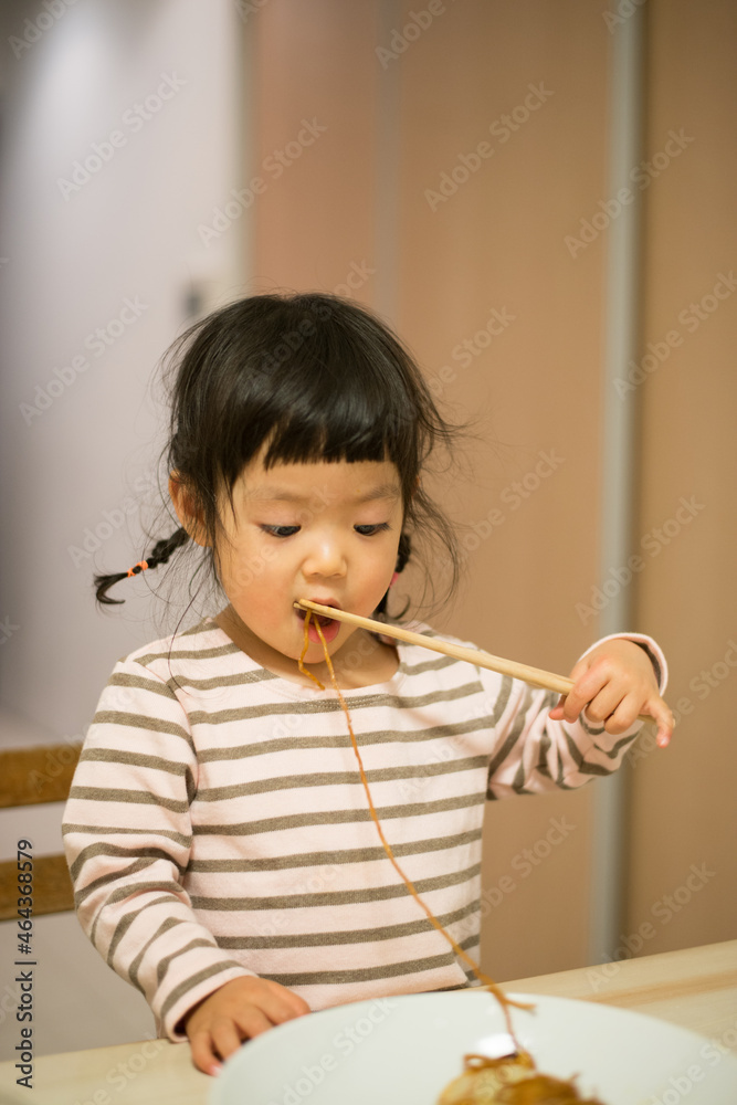 お箸で焼きそばを食べている女の子