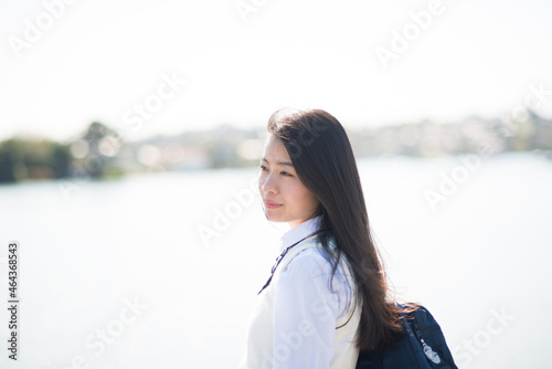 水辺に立っている制服姿の女子高生 photo