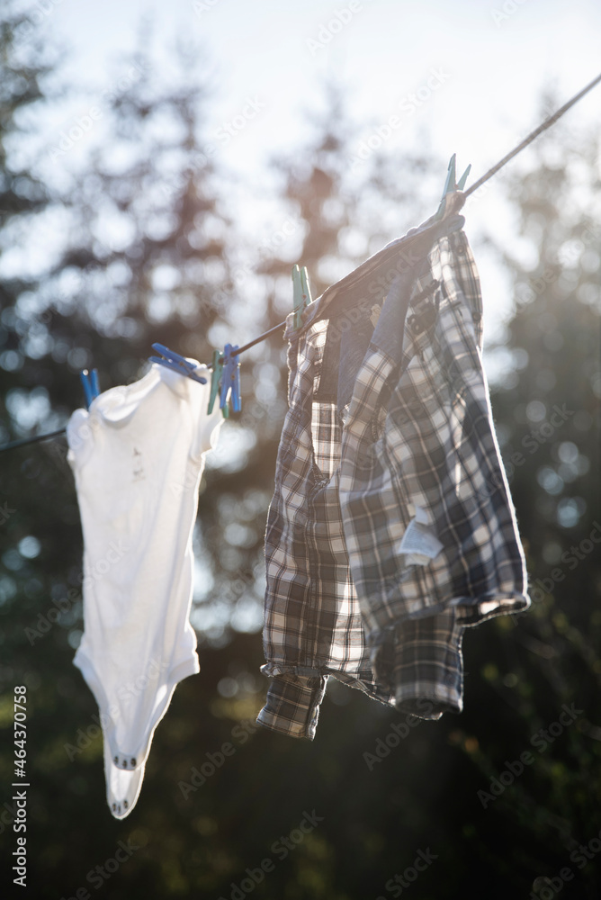 Dziecięce uprane ubrania na lince do prania na dworze - obrazy, fototapety, plakaty 