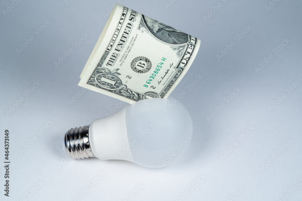 Economical light bulb and money (dollars). Energy saving. Economical light bulb and money (dollars). Energy saving.