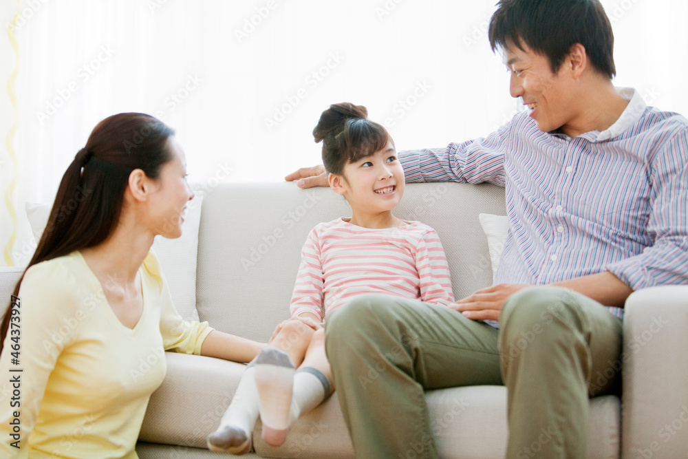 ソファでくつろぐ家族3人 ソファでくつろぐ家族3人
