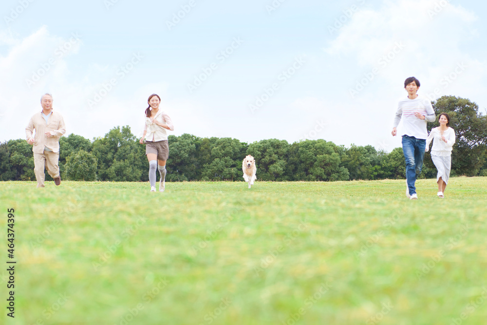 走っている4人家族と犬