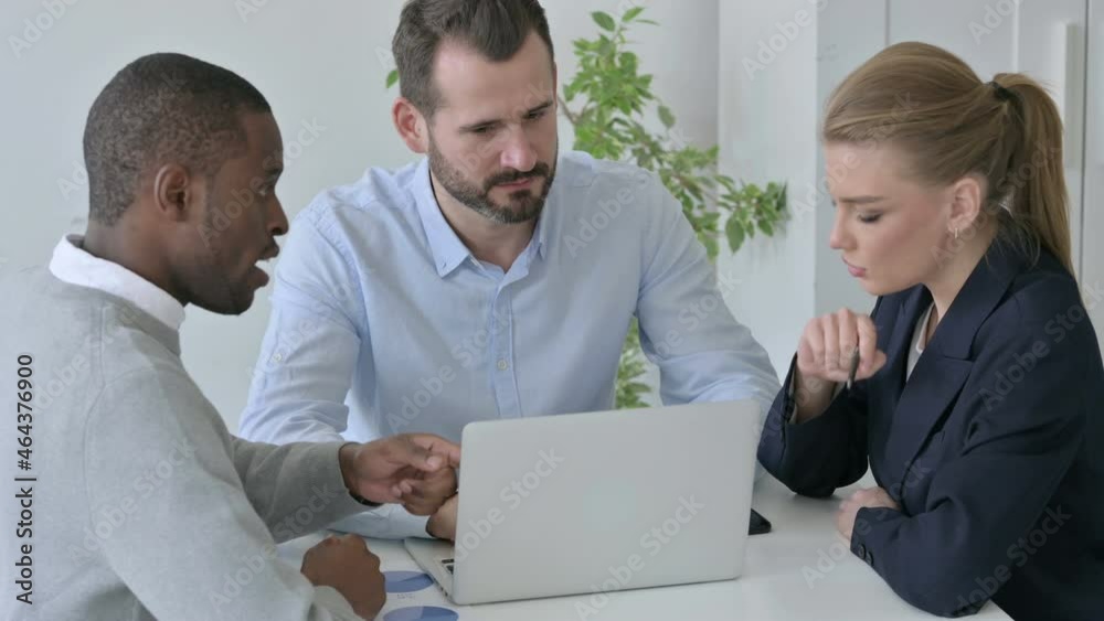 Male and Female Business People with Laptop having Discussion in Office Male and Female Business People with Laptop having Discussion in Office