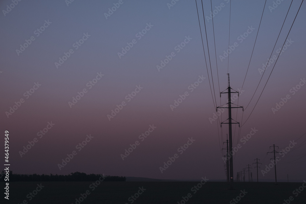 Electric poles at sunset, late at night.
