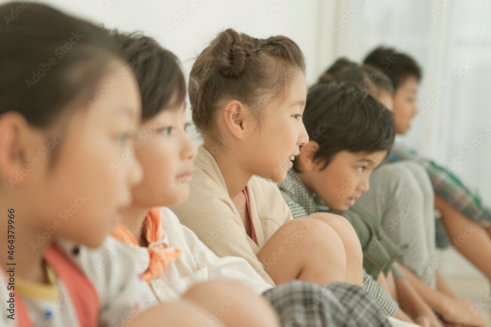 一列に座る小学生