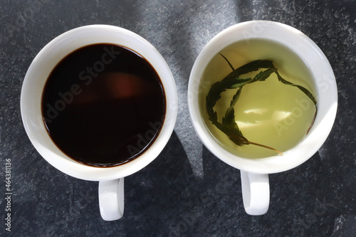 Top view hemp tea and black coffee in a white cup on a stone background