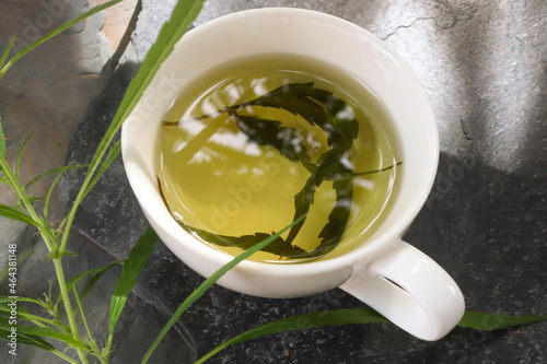 Top view hemp tea in a white cup with cannabis leaf