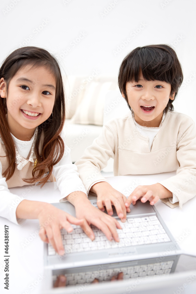 ノートパソコンを操作している子供2人 ノートパソコンを操作している子供2人