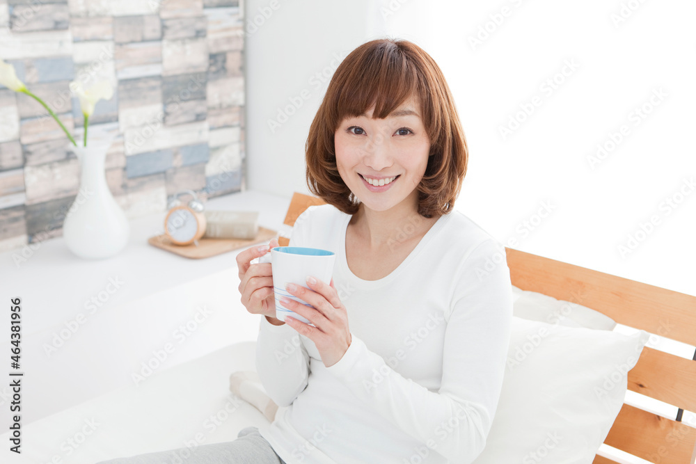 ホットドリンクを持つ女性