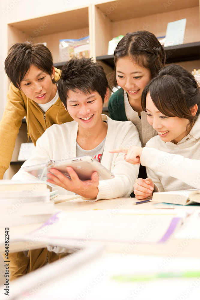 タブレットPCを見る大学生4人 タブレットPCを見る大学生4人