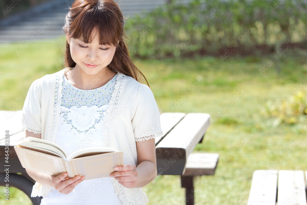 公園で本を読んでいる女性