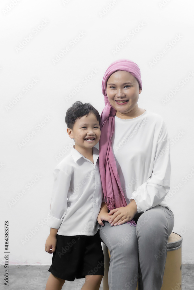Young adult female cancer patient spending time with son at home, relaxing on the couch. Cancer and family support concept. Young adult female cancer patient spending time with son at home, relaxing on the couch. Cancer and family support concept.