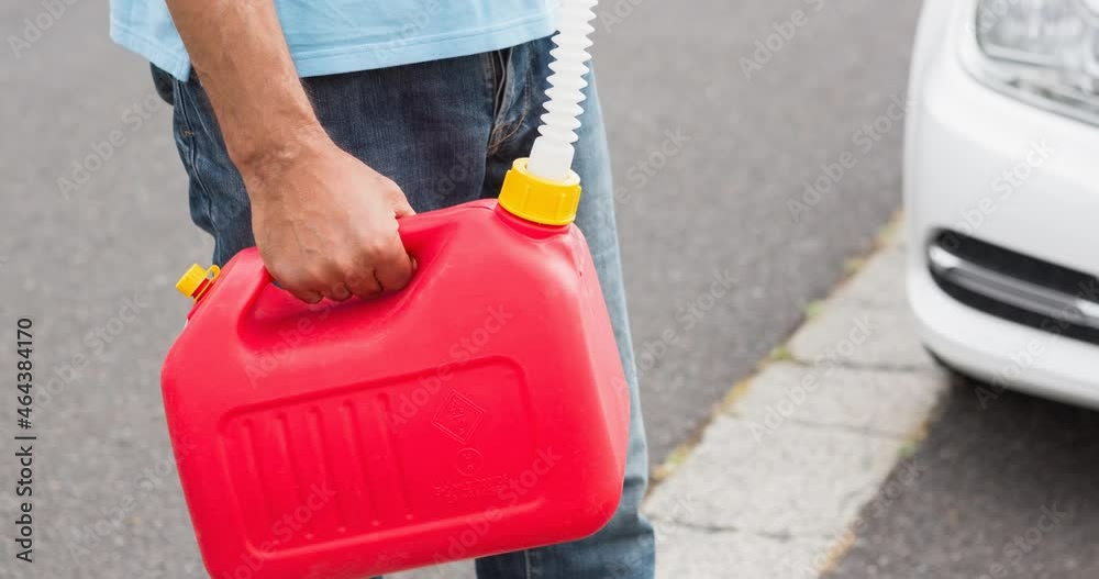 Midsection of caucasian man holding red plastic fuel jerrycan Midsection of caucasian man holding red plastic fuel jerrycan