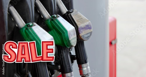 Animation of sale text in red over row of fuel pumps at petrol station photo