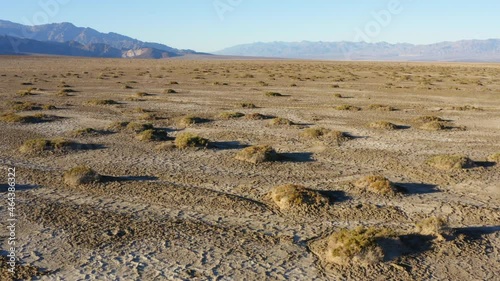 Drone flight over vast rough terrain covered with salt pans at Badwater basin of Death valley National Park. Aerial.