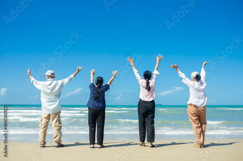 Happy Asian family holding hands and having fun together on tropical beach. Happy family standing on the beach. family travel and vacations concept