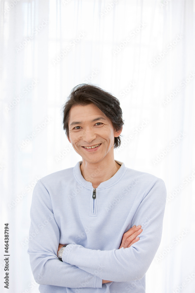 腕組みをする笑顔の中高年男性